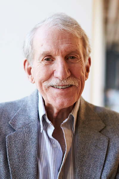 portrait-of-smiling-senior-businessman-in-modern-o-XY8GLE3.jpg